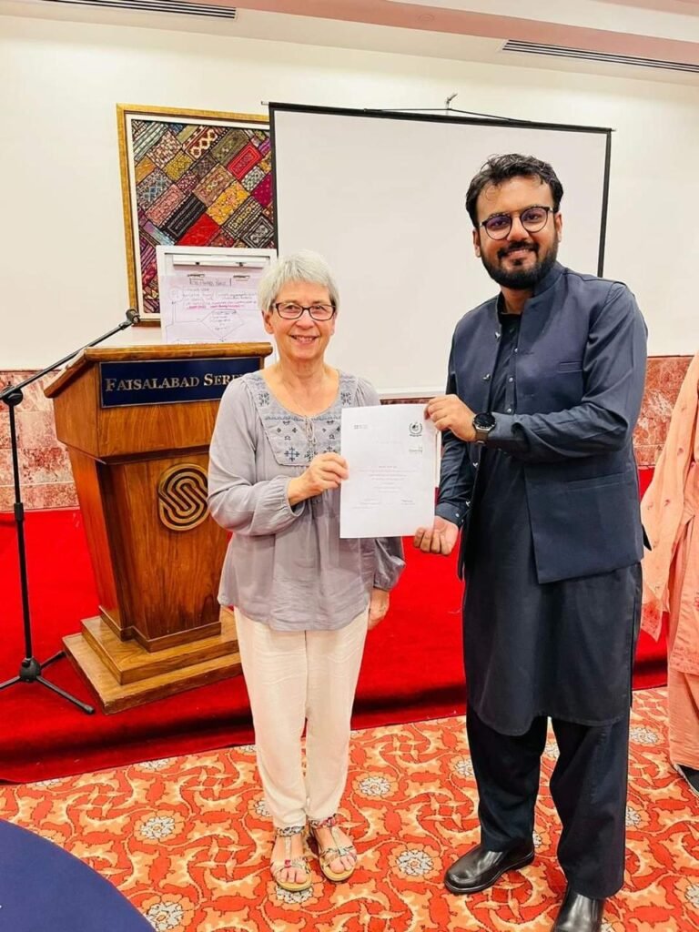 Dr. Ali Tahir receiving a certificate from Professor Elena Gaura